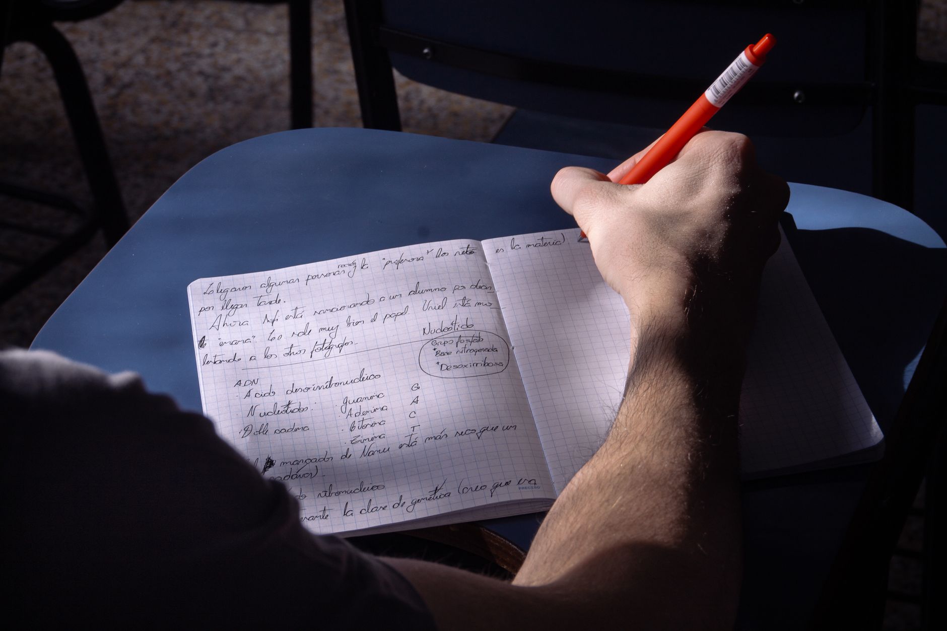 Een student maakt aantekeningen in een klaslokaal bij natuurlijk licht, terwijl ze een nieuwe werkmethode oefent.